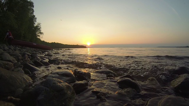 日落时湖岸上的波浪视频素材