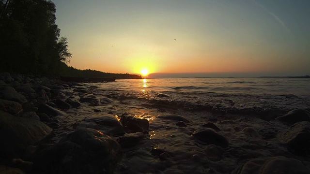 日落时湖岸上的波浪视频素材