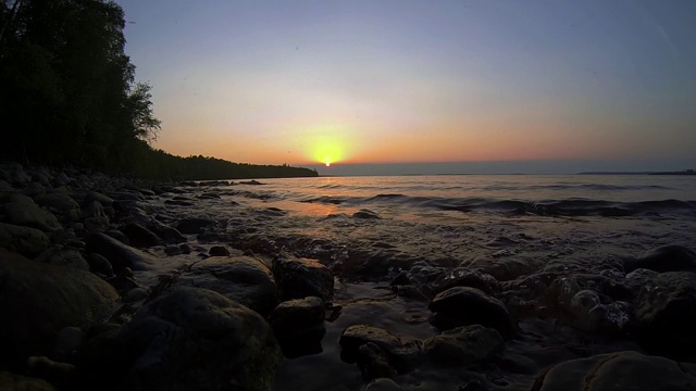 日落时湖岸上的波浪视频素材