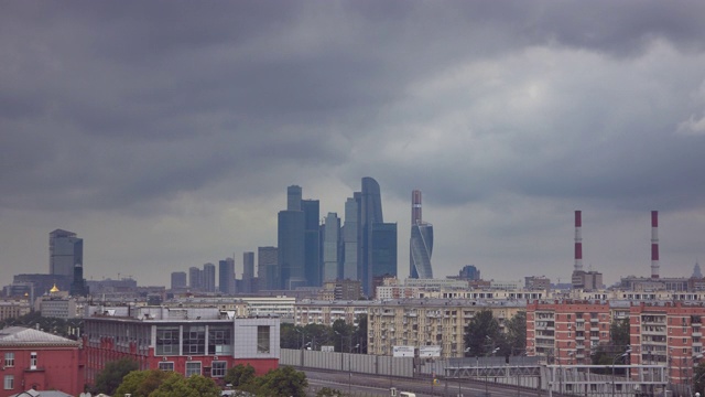 在多云的天气下，以办公摩天大楼为背景，以公寓大楼为前景的城市景观视频素材