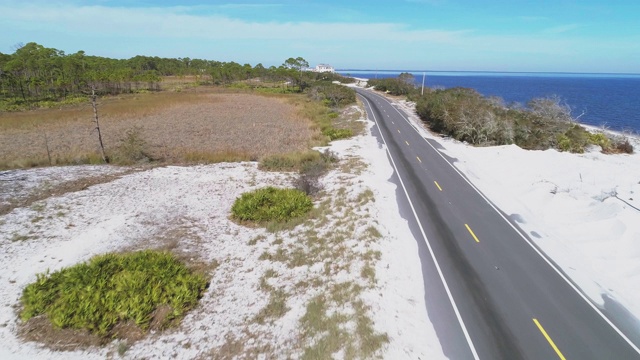 沿着大西洋海岸的白色沙丘和松树林的高速公路。无人机视频与电影向前的摄像机运动。视频素材