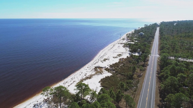 沿着大西洋海岸的白色沙丘和松树林的高速公路。无人机视频与电影的下降和摄像机周围的移动。视频素材