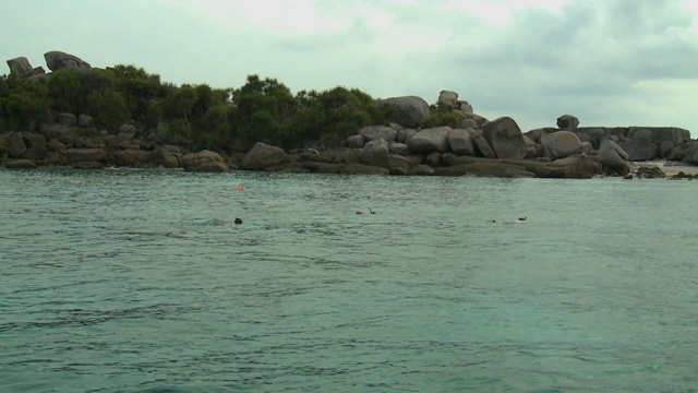 人们在大岩石附近浮潜视频素材