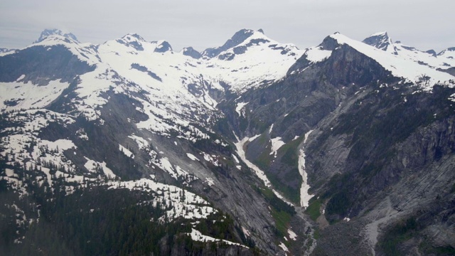 航拍:阴天里，加拿大温哥华，美丽的雪山之间的山谷视频素材