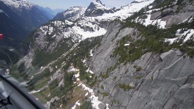 航拍:在加拿大温哥华美丽的雪山上飞行，郁郁葱葱的山谷视频素材