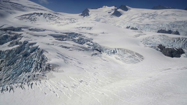 空中缩小:雪谷和高山与明亮的，蓝天之上-门登霍尔冰川，阿拉斯加视频素材