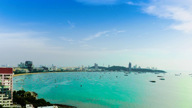 白天，芭堤雅的海岸线、海滩、海面上漂浮着船只和摩天大楼的全景。视频素材