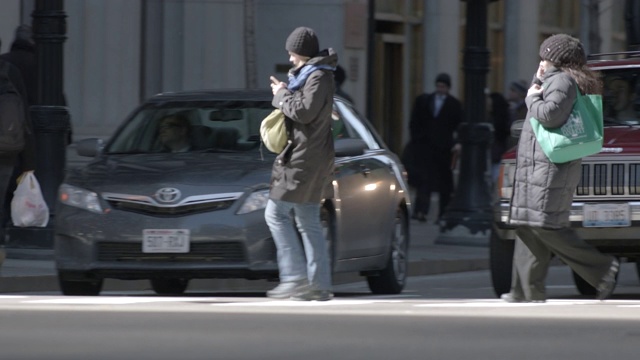 芝加哥城市街道的广角。行人可见横过人行道和人行横道。街道上可见汽车、出租车和货车行驶。视频素材