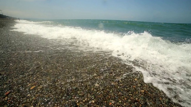 海浪在卵石滩上冲浪，暑假在海边。视频素材