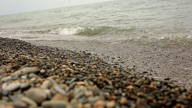 海浪在卵石滩上冲浪，暑假在海边。视频素材