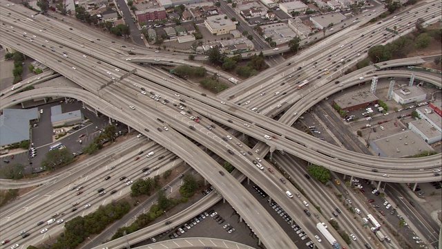 港110号公路和101号公路交叉路口的架空图。鸟瞰图的汽车，交通。这张照片展示了洛杉矶市中心的天际线，会议中心。高层建筑、摩天大楼、酒店、写字楼。立交桥,坡道。视频素材