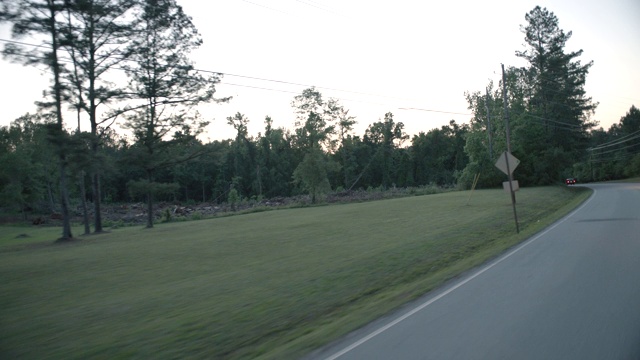 工艺板3/4前左侧农村地区或乡村道路两旁有树木。房子可见。视频素材