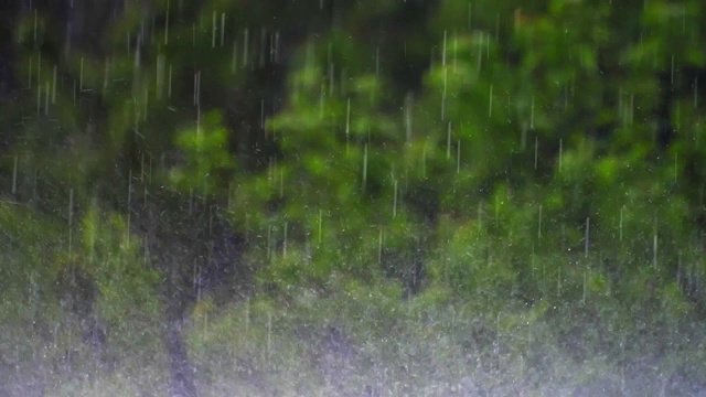 在大雨中，雨滴落在地面上的慢动作视频素材