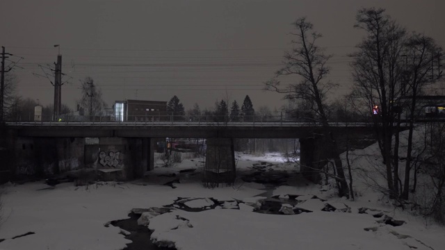 冬季城市的旅客列车在大桥上运行的夜景视频素材