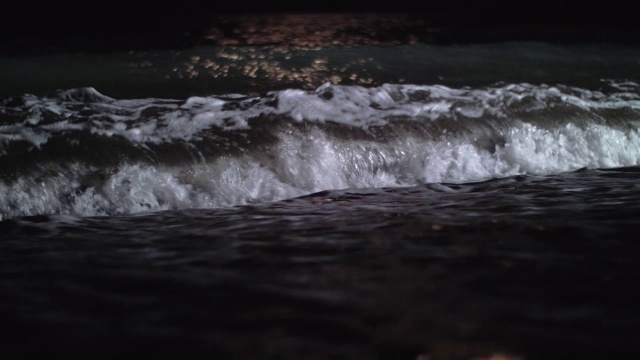 夜景，黑暗的海浪翻滚在海岸上视频素材