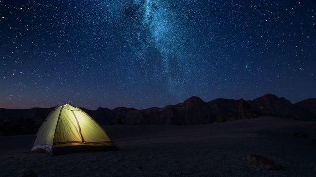 冒险浪漫的夜晚时间和会见黎明在一个繁星点点的夜晚在高山上黎明前的旅游帐篷视频素材