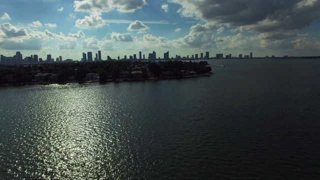 迈阿密市中心的航拍全景，由一架无人机在阳光明媚的夏天飞越蓝色海洋拍摄。4K镜头慢动作。船在背景。视频素材