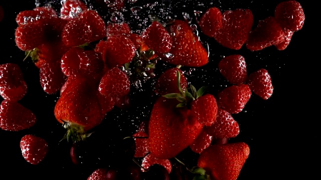 混合成熟的浆果落入水中在一个黑色的背景视频素材