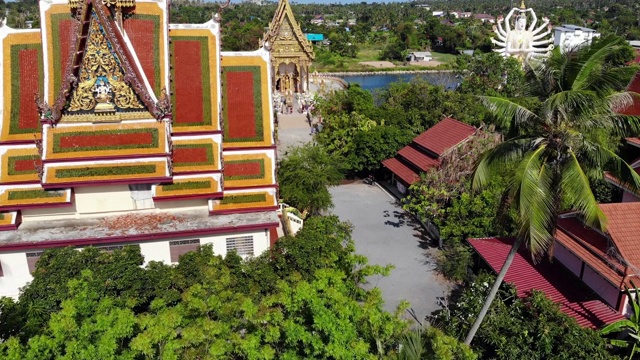 湖边的佛寺。在阳光明媚的日子里，苏梅湖附近的屋顶和寺庙的雕像被无人机俯视。白莲寺的微笑佛和观音视频素材