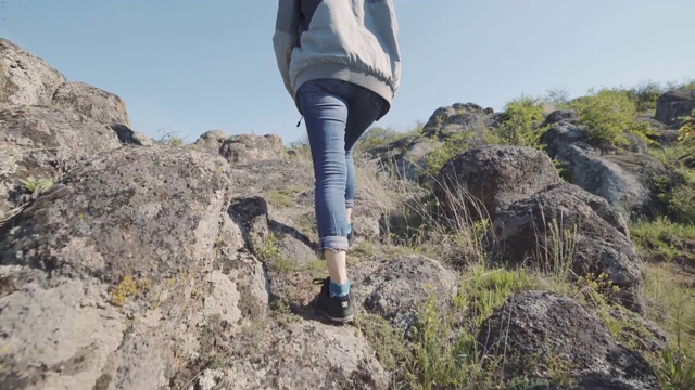 一个年轻的女旅行者在峡谷的山中行走。日落或日出的慢动作拍摄视频素材