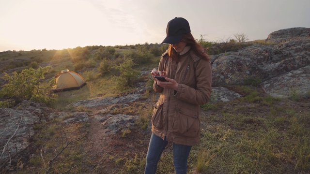 一个年轻的女旅行者在峡谷的山中行走。女人用智能手机搜索地点视频素材