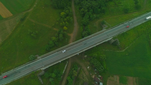 鸟瞰图沿乡村地区的汽车路线。雾与雾在融合。美丽的风景，乡村道路和汽车。4 k。视频素材