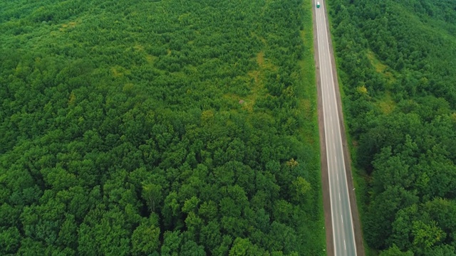 鸟瞰图的白色卡车行驶在乡村道路上的森林。4 k。视频素材