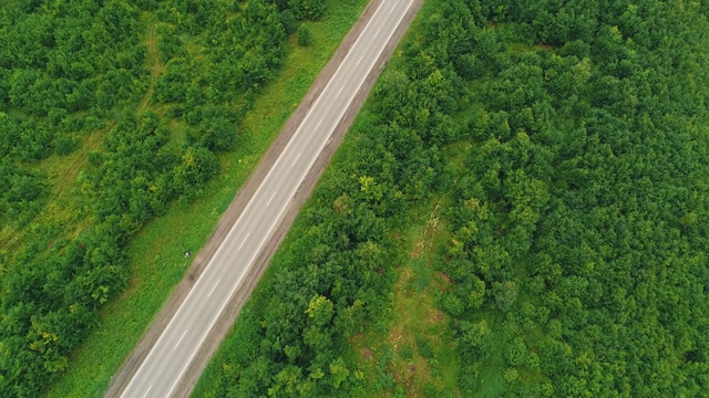 明亮的汽车鸟瞰图，行驶在乡村道路在森林。4 k。视频素材