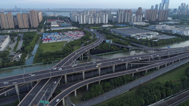 无人机的高速公路多层次交叉道路与移动的汽车在日落。汽车在多层路口行驶，是城市的概念。苏州城市,中国。视频素材