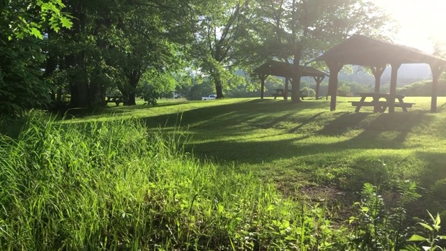 休息区和野餐区与汽车经过靠近黄昏桥和教堂沿着农场伯特利，美国缅因州视频素材