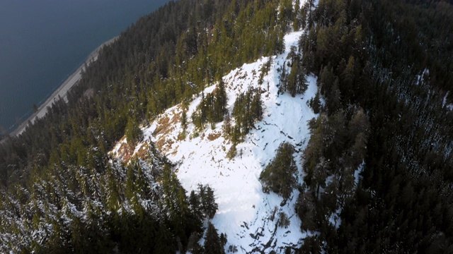 空中盘旋:白雪皑皑的山脉和湖边的森林，上面有白云——斯诺夸尔米，华盛顿视频素材