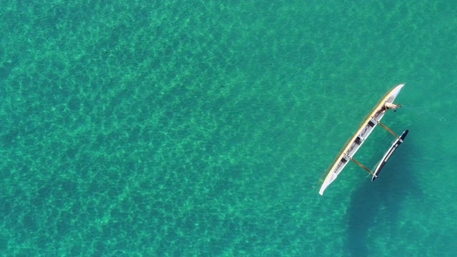 航拍左图:阳光明媚的日子里，浅海中亮蓝色的小船——夏威夷大岛视频素材