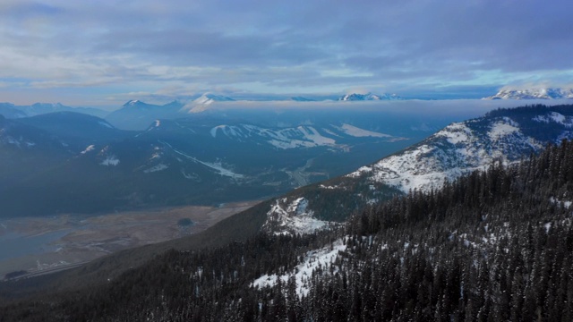 空中全景图:高高的，白雪覆盖的，森林覆盖的山脉延伸到地平线，下面有湖-斯诺夸尔米，华盛顿视频素材