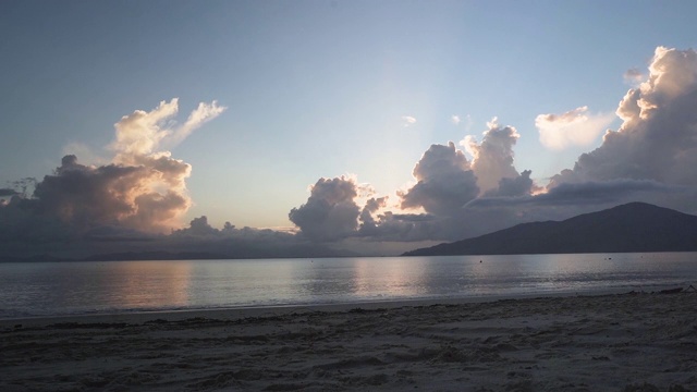 日落海滩随着阳光穿过云层而流逝视频素材