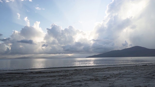 日落海滩随着阳光穿过云层而流逝视频素材