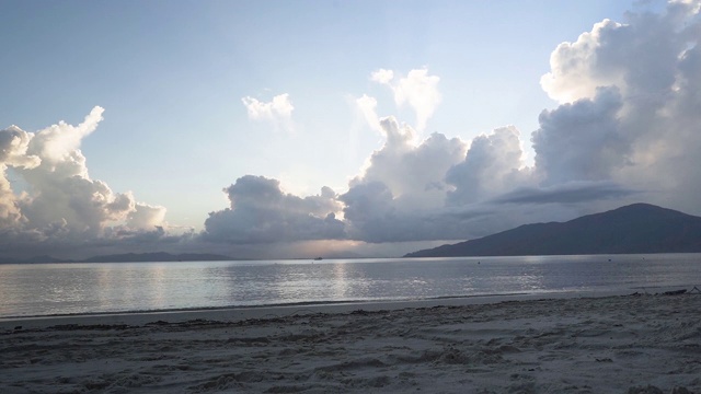 日落海滩随着阳光穿过云层而流逝视频素材