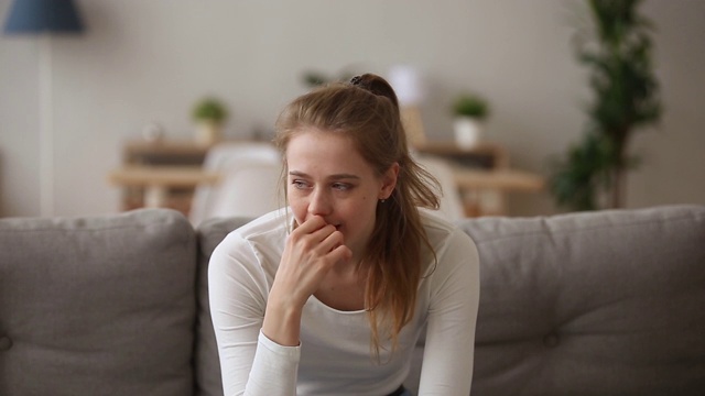 焦虑不安的女孩独自坐在家里担心问题视频素材