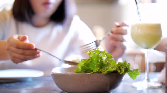 女人在餐厅吃沙拉和健康食品，SKOW运动，多莉拍摄视频素材