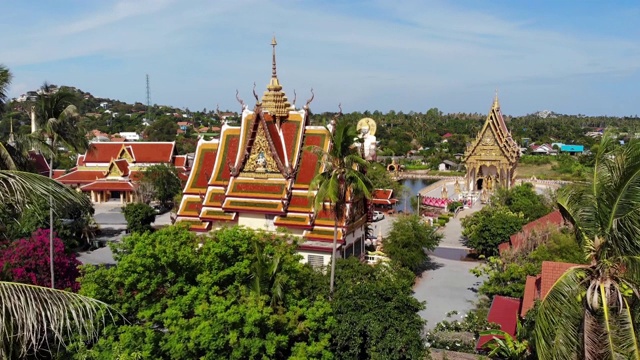 湖边的佛寺。在阳光明媚的日子里，苏梅湖附近的屋顶和寺庙的雕像被无人机俯视。白莲寺的微笑佛和观音视频素材