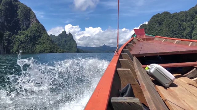 水溅在带着手提箱快速移动的旅游木船旁边视频下载