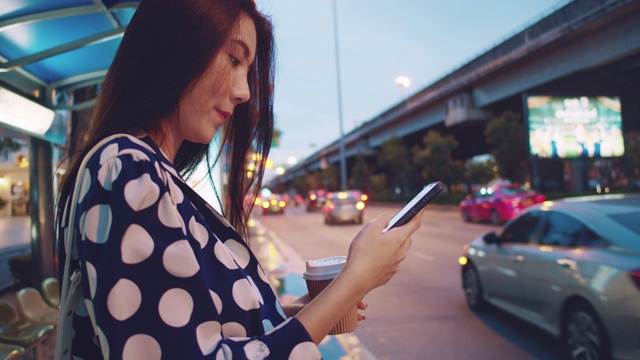 年轻的亚洲女子在曼谷等出租车。视频素材