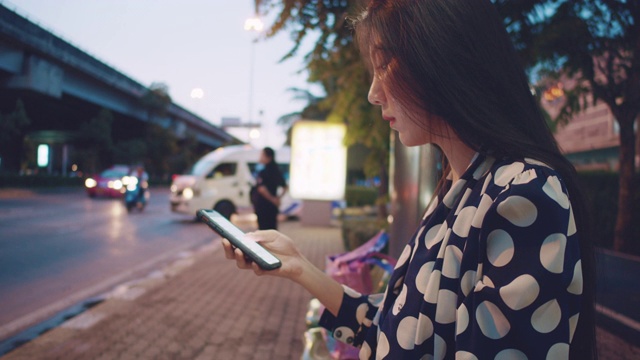 年轻的亚洲女子在曼谷等出租车。视频素材