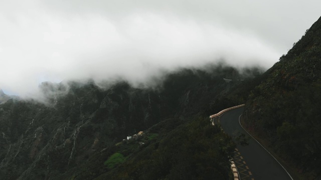 静态鸟瞰图-巨大的云飞得很低，在一个孤独的道路上没有汽车，蛇形高的山脊。特内里费，加那利群岛，西班牙视频素材