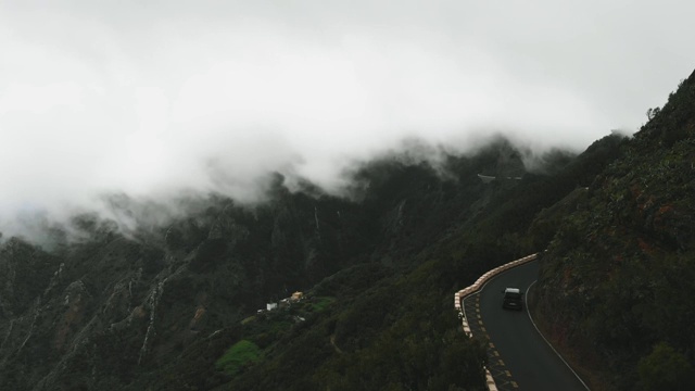 鸟瞰图-汽车驾驶在一个潮湿和危险的道路上，浓密和厚的云飞过他们很低。你可以用手触摸云彩。视频素材