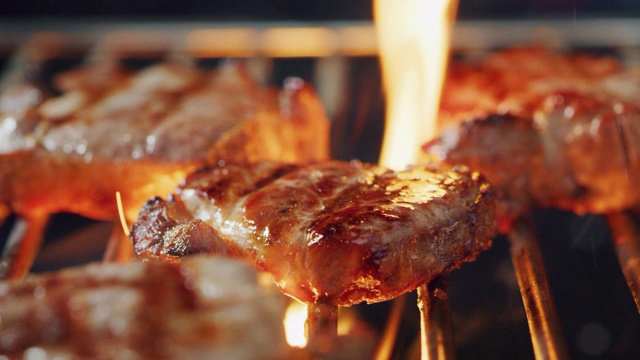 特写肉在烧烤烧烤在高火焰上烹饪。视频素材