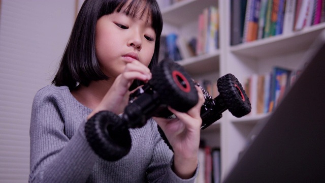 小女孩独自在学校做机器人。有天赋的女孩，她试着自己修理机器人。技术和教育理念。视频素材