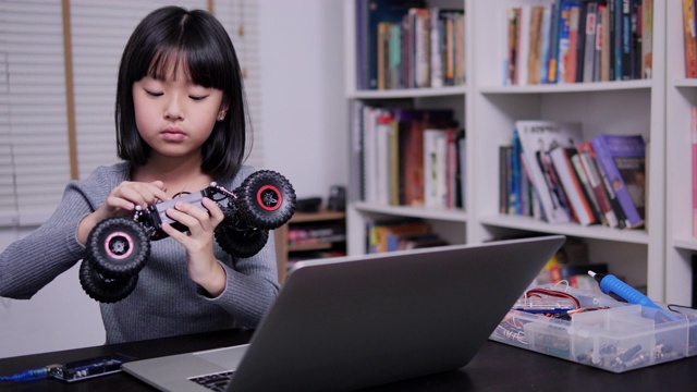 小女孩独自在学校做机器人。有天赋的女孩，她试着自己修理机器人。技术和教育理念。视频素材