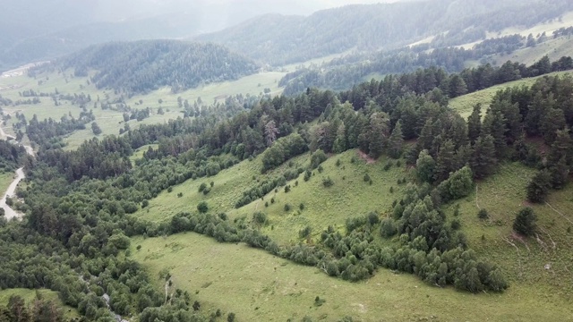 鸟瞰图。飞过绿草嶙峋的山丘。在美丽的云中飞过高山视频素材