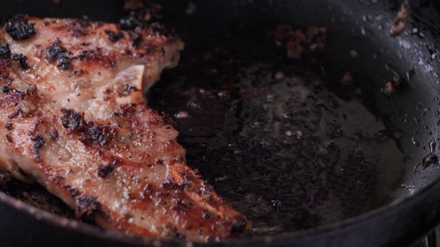 特写在热锅里烤猪肉牛排视频素材