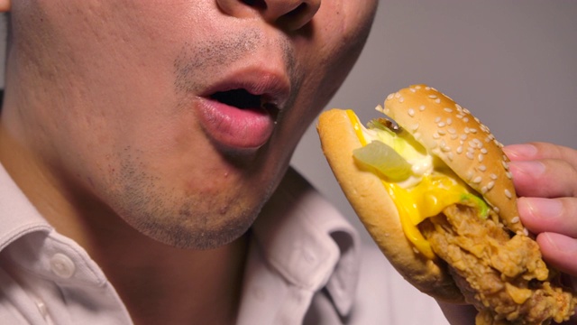 男人在吃鸡肉汉堡视频素材